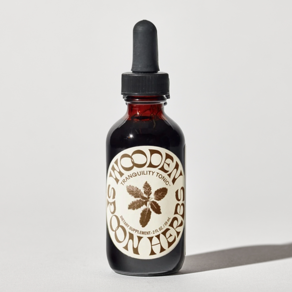Bottle of 'Wooden Spoon' tonic with a dropper on a light gray background