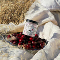 Jar of Magic Mag Cherry with cherries on a plate outdoors